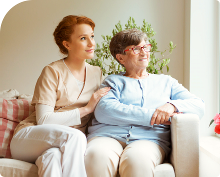 caregiver and senior woman sitting down smiling