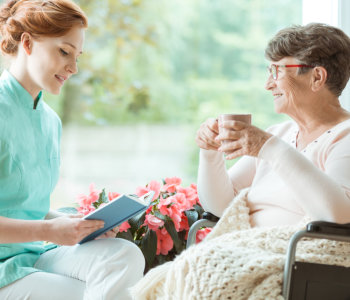 Caregiver reading a book to elder women