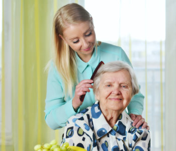 caregiver combing elder woman's hair