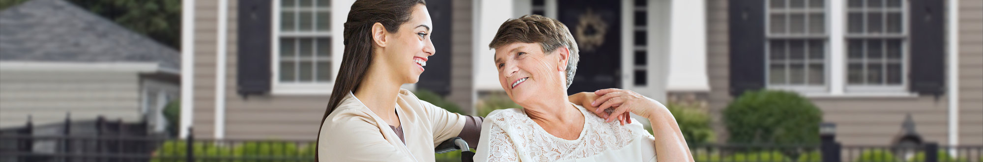 caregiver and elder woman smiling to each other