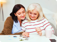 caregiver reminding her senior patient to take her medication